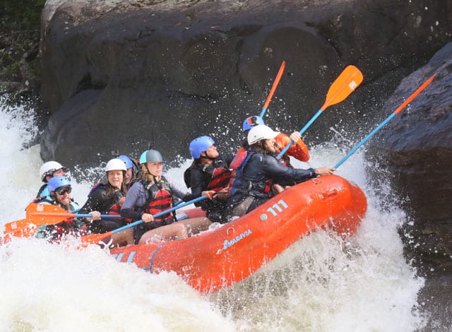 Adventure Office Software group of whitewater rafters navigate the rapids on the river